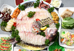 사에 차려진 여러 반찬들과 놓여진 생선회 모습